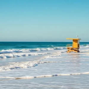 A peaceful view of Lake Worth Beach showing lifeguard stations and beachgoers enjoying the water.