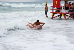 A swimmer rescuing a child from a rip current at the beach.