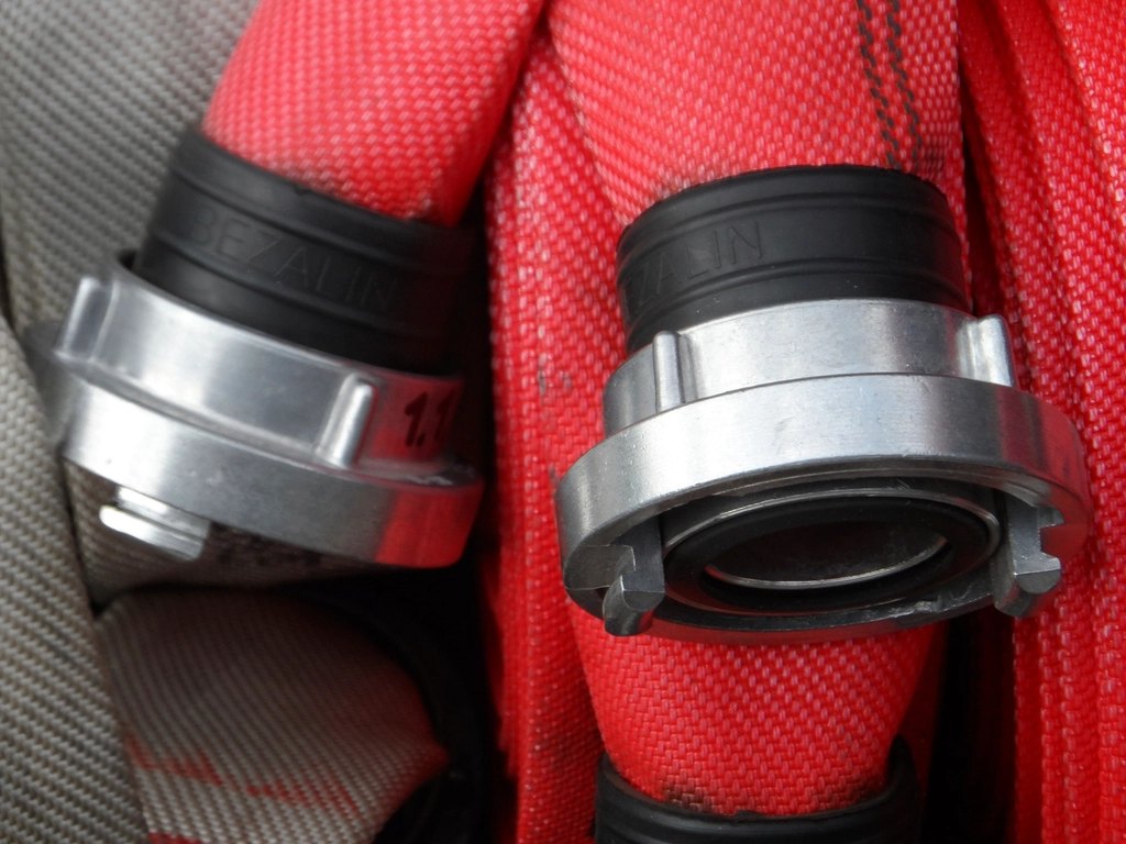 Red fire hose with metal couplings